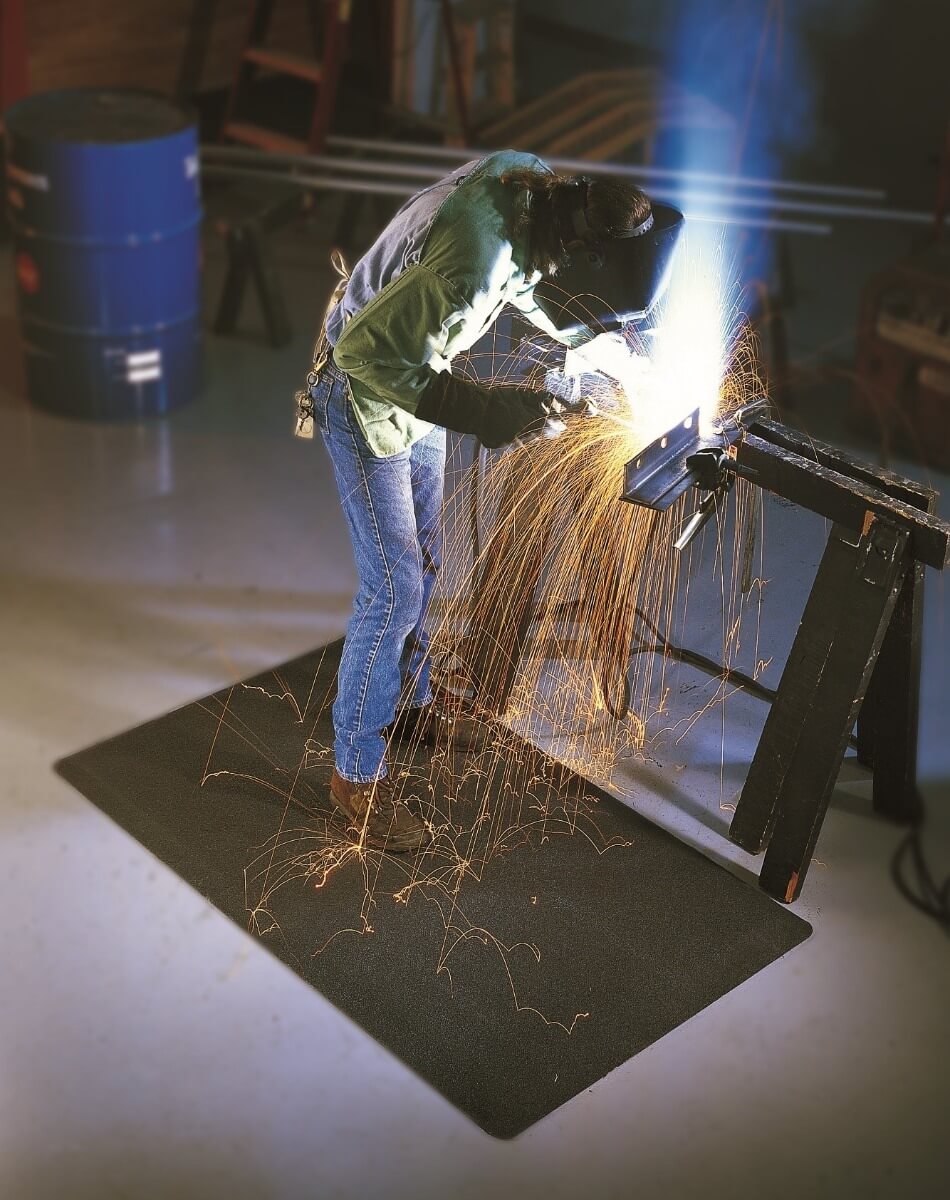 Welder on an anti-fatigue welding mat